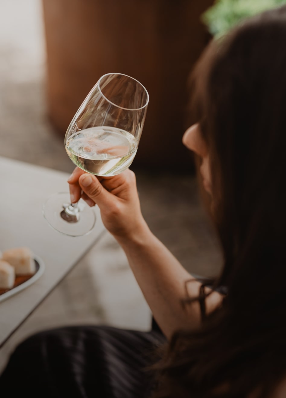 Donna di spalle che sorseggia un calice di prosecco